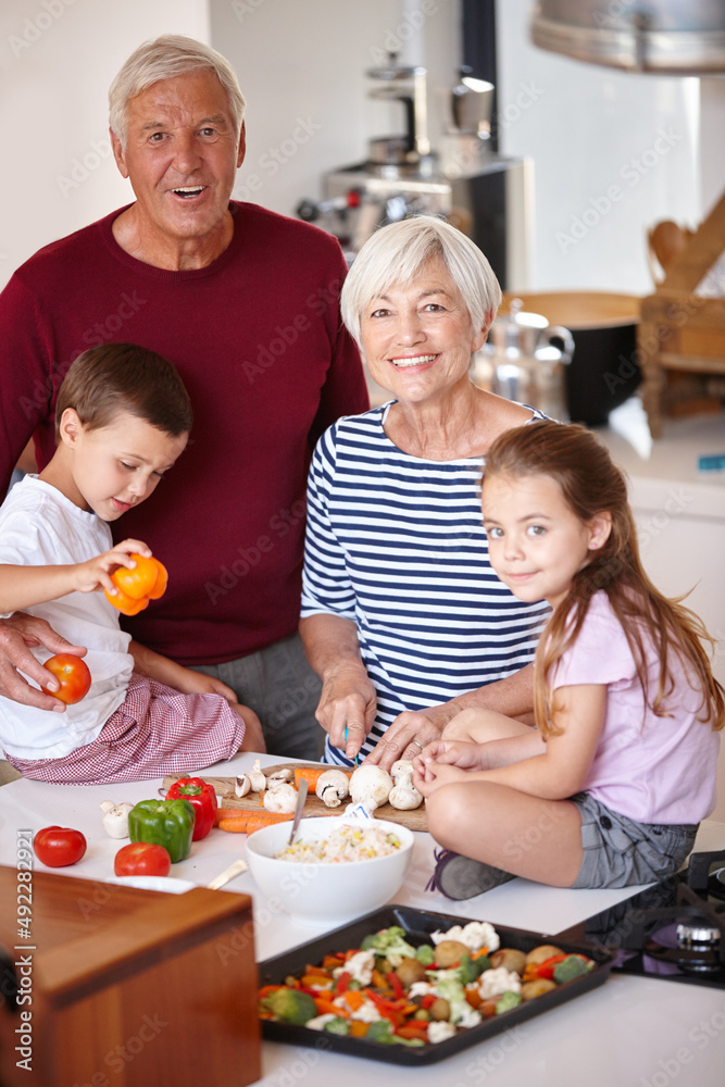 Dinner will be ready in no time. Portrait of a grandparents preparing a meal with their grandchildren. Dinner will be ready in no time. Portrait of a grandparents preparing a meal with their grandchildren.