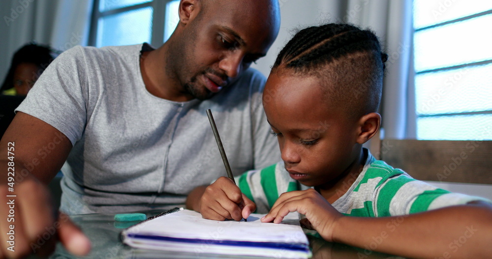 Father mentoring son, dad helping kid with homework study Father mentoring son, dad helping kid with homework study