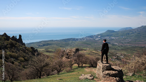 A man climbs into the mountains, Crimea, sunny summer, blue sky, high mountains. hiking in the mountains © Константин Чернышов