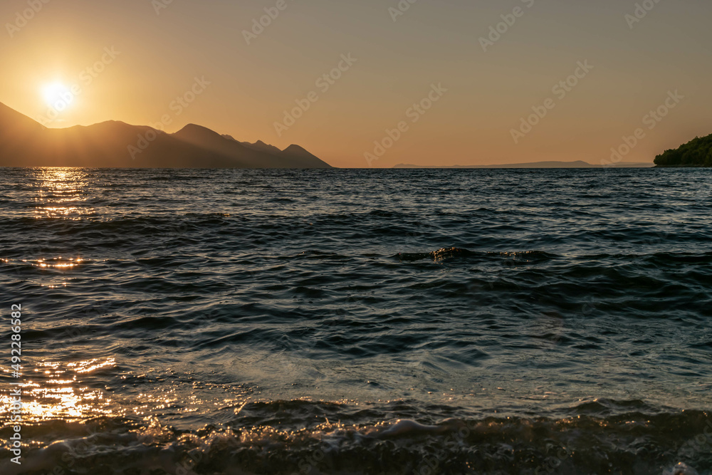 the outline of the mountains at sunset, the shore of the adriatic sea in croatia, summer sunset by the sea