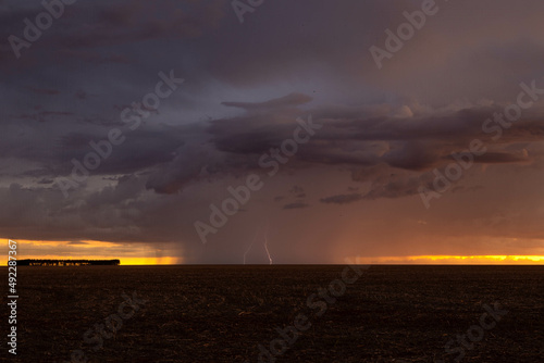 A lightning storm during sunset on the farm.