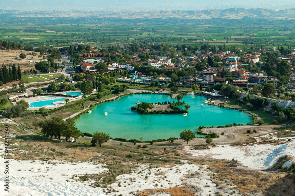 Natural travertine pools and terraces in Pamukkale. Cotton castle in southwestern Turkey. Tourists walking and bathing in Natural travertine pools