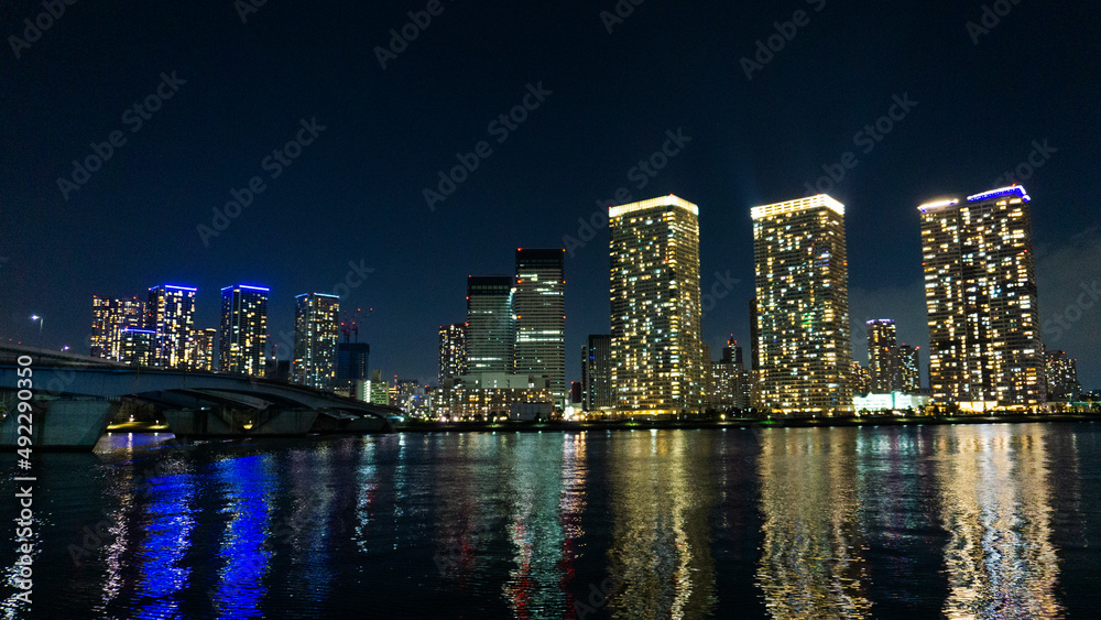 Night view of a high-rise condominium along an urban river_44