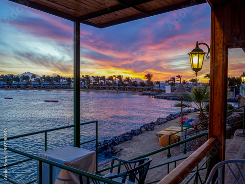 Fototapeta Naklejka Na Ścianę i Meble -  Sunset over the red sea palm tree silhuettes hotel in Hurgada, Egypt Sunrise and beach at the luxury hotel. copy space