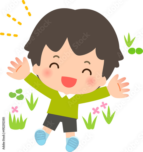 草むらに寝転がる笑顔の男の子
