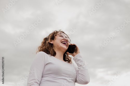 Mujer con lentes usando su celular. Concepto de telefonía.