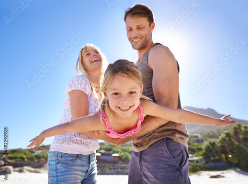 Playful on the beach. Shot of a happy young family being playful at the beach. © Marius V/peopleimages.com