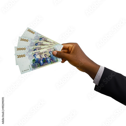 Black hand holding 3d rendered 2000 Algerian dinar notes isolated on white background photo