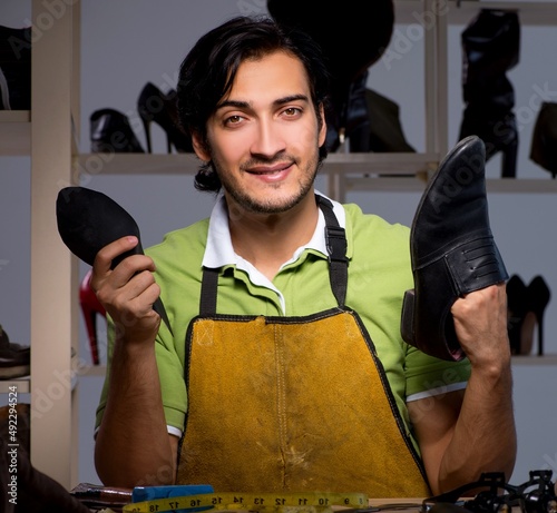 Young shoemaker in workshop at night