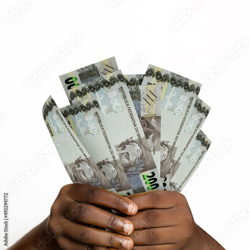 Black hands holding 3D rendered 200 Brazilian reais notes. closeup of Hands holding Brazilian real currency notes photo