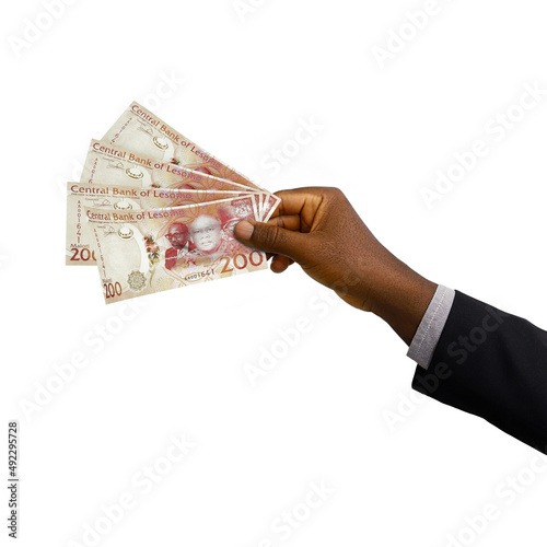 Black hand with suit holding 3D rendered Lesotho loti notes isolated on white background photo