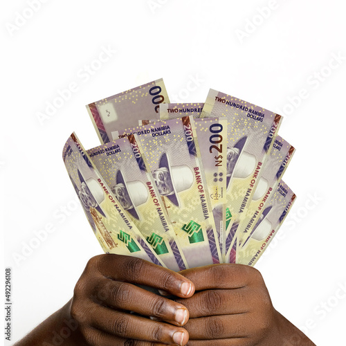 Black hands holding 3D rendered 200 Namibian dollar notes. closeup of Hands holding Namibian currency notes