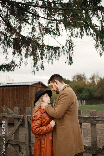 Romantic couple hugging on a farm near a fence