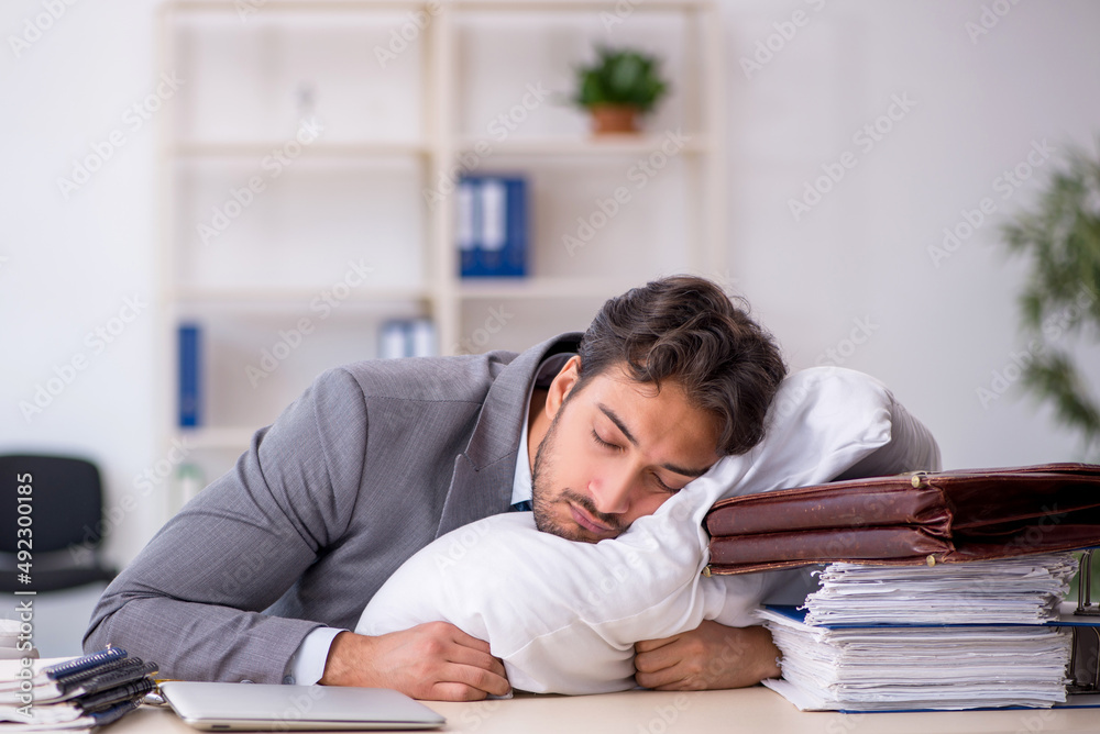 Young male employee in oversleeping concept Young male employee in oversleeping concept