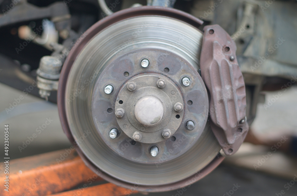 Used car wheel hub. Blurred image, disc brakes have wear and tear.