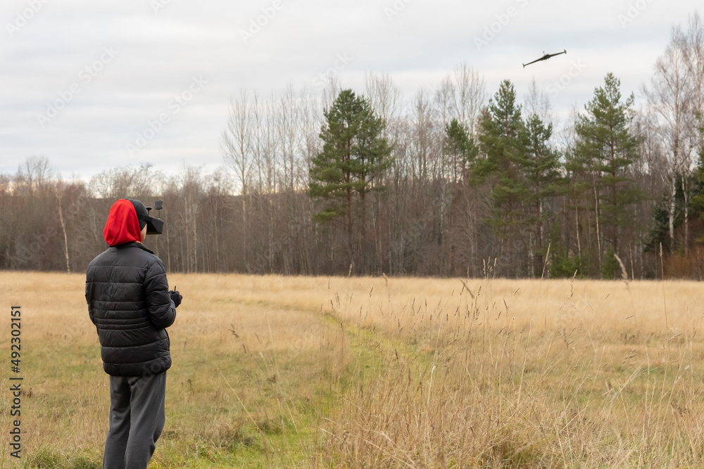 Young man launches rc plane into sky. Teenager with glasses playing with toy radio-controlled airplane outdoors. Boy holding radio remote controller. High quality photo Young man launches rc plane into sky. Teenager with glasses playing with toy radio-controlled airplane outdoors. Boy holding radio remote controller. High quality photo