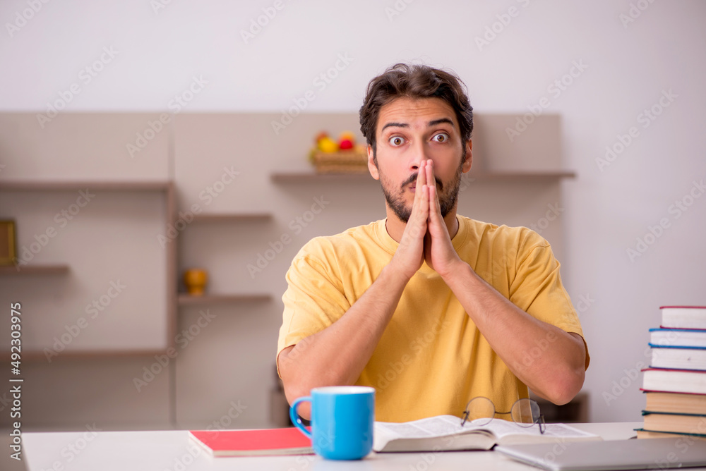 Young male student preparing for exams at home