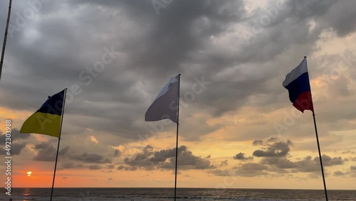 russian and ukrainian flags waving in the air with a white flag for peace in costa rica during the 2022 war conflict
