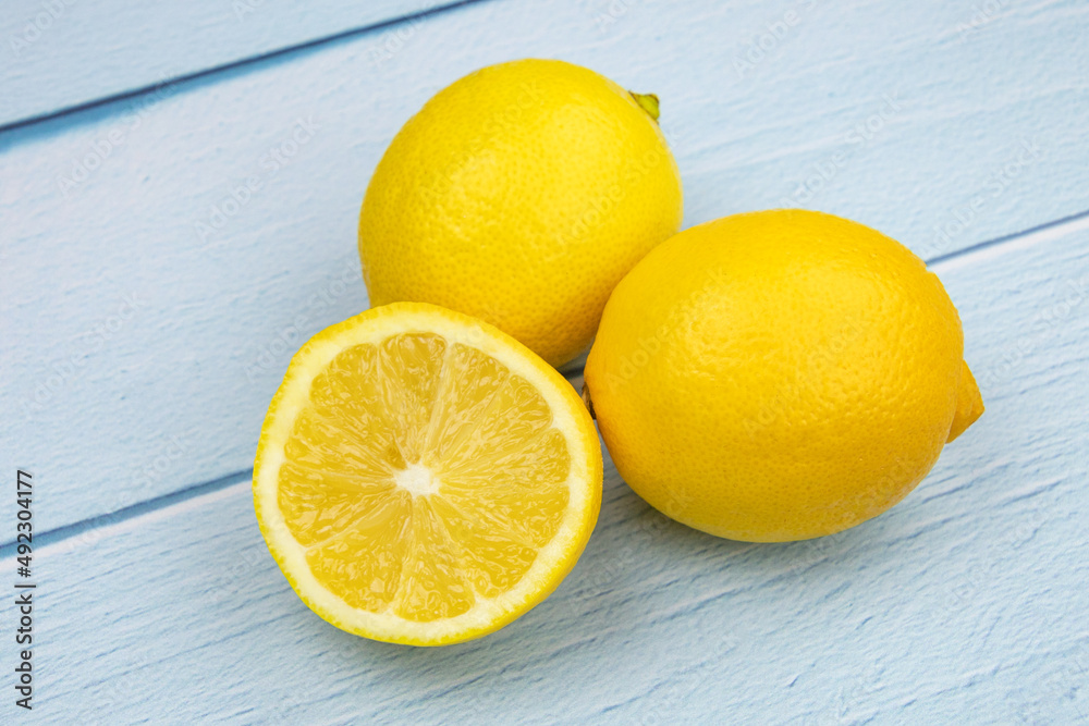 cut lemon and whole lemon on a blue background cut lemon and whole lemon on a blue background