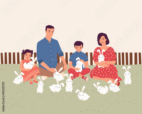 Family With Two Children Having Fun Time At The Rabbit Farm.