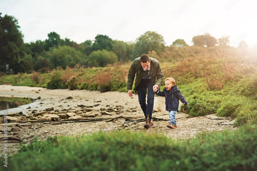 Naklejka premium Enjoying the day with dad. Shot of a father out for a walk with his little son.