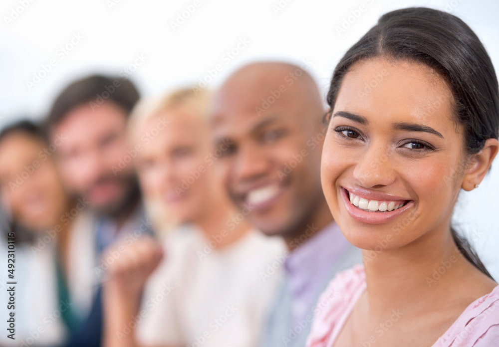 Shes got ambition. Portrait of an attractive business woman smiling at the camera with a row of business people behind her. Shes got ambition. Portrait of an attractive business woman smiling at the camera with a row of business people behind her.