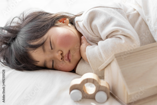 昼寝している赤ちゃんと、オモチャの家と車(1歳8ヶ月、日本人、女の子)。子供との生活設計のイメージ