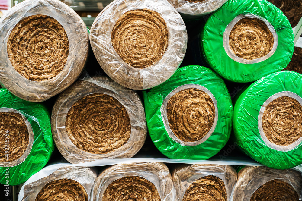 Rolls with mineral wool for insulation of houses and various premises. Trade in heat-insulating materials in the wholesale and retail network. Close-up Rolls with mineral wool for insulation of houses and various premises. Trade in heat-insulating materials in the wholesale and retail network. Close-up