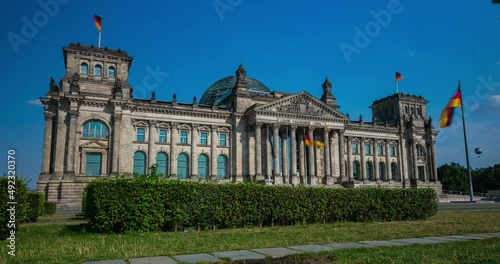 Berlin, Germany - September 16, 2021: Time lapse at the German parliament, Reichstag or Bundestag in the capitol of Germany. German flags waving in front of the building. Imperial Diet in Berlin photo