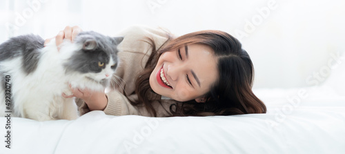 Photography Young Asian woman playing with cat at home