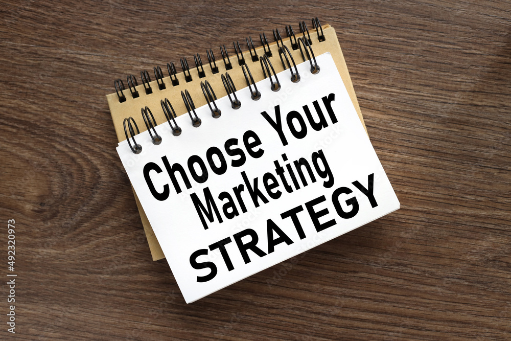 Choose Your Marketing Strategy. two notebooks on the table. text on notebook