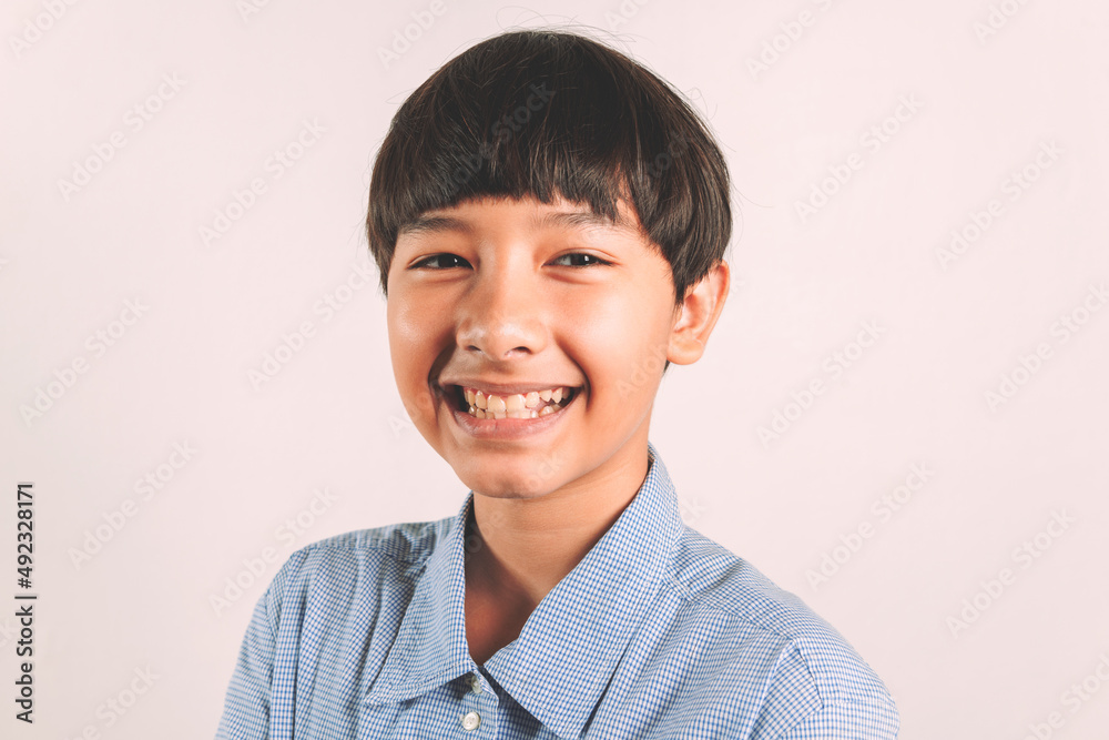 Portrait of adorable young happy smiling mixed race boy looking at camera wearing a casual school look in a good mood, carefree childhood. Isolated on white background for copy space and graphics Portrait of adorable young happy smiling mixed race boy looking at camera wearing a casual school look in a good mood, carefree childhood. Isolated on white background for copy space and graphics