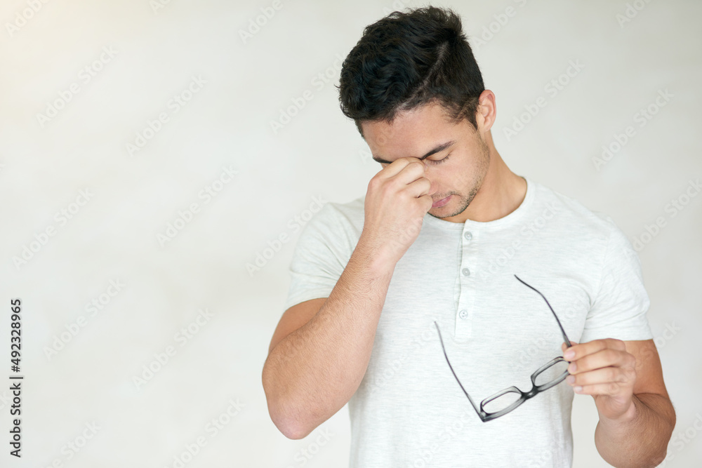 This is so not cool. Studio shot of a young man looking stressed against a light background. This is so not cool. Studio shot of a young man looking stressed against a light background.