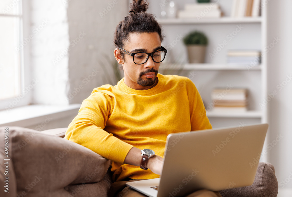 Black male freelancer working at laptop at home Black male freelancer working at laptop at home