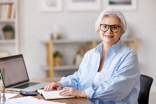 Smiling middle aged businesswoman working in home office