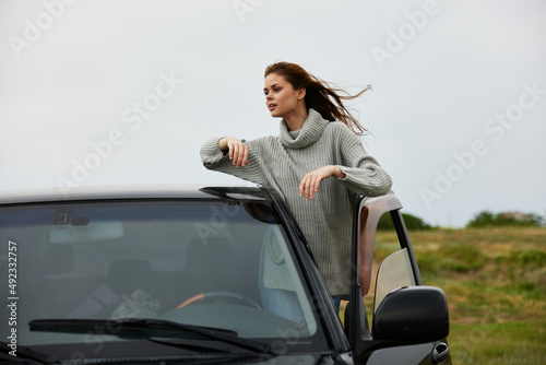 portrait of a woman with red hair in a sweater near the car nature female relaxing