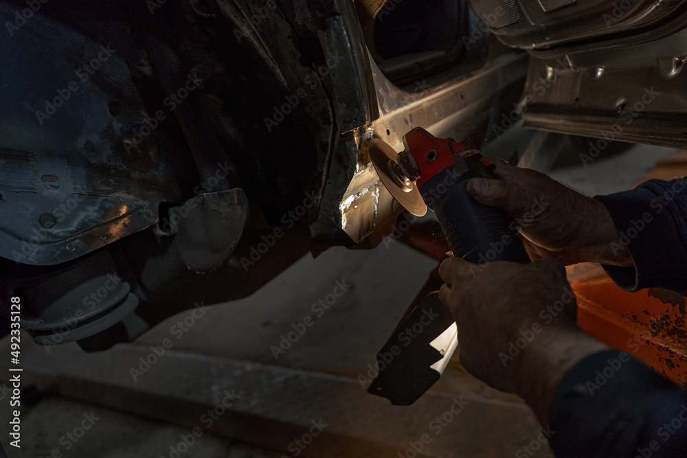 Man repairing car and working with tool