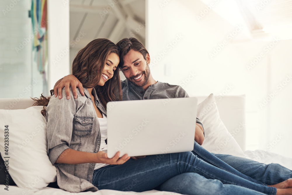 Love is sharing your wifi password. Shot of an attractive young couple spending quality time at home. Love is sharing your wifi password. Shot of an attractive young couple spending quality time at home.