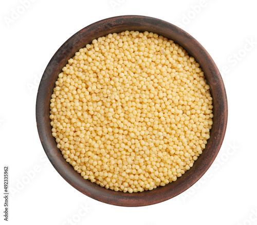 Dry millet in clay bowl isolated on white. Top view