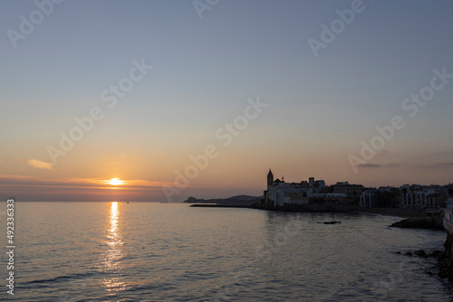 Picturesque sea evening landscape. Sunset over the mediterranean sea. Evening city, sea and sunset. The sun is above the horizon line. © Sergei