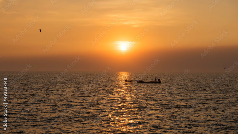 fisherman sailing boat on sea at sunset, Bang Pu, Samut Prakan