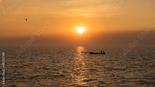 fisherman sailing boat on sea at sunset, Bang Pu, Samut Prakan © Blanscape