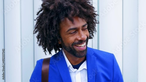 Handsome man with curly hair from brazil  and fashionable clothes. Young business man on a working break spending time outdoor the offices photo