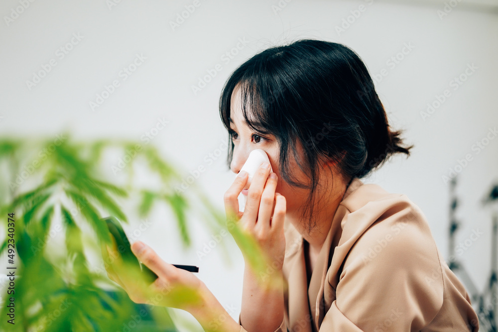 笑顔でメイクをする若い女性