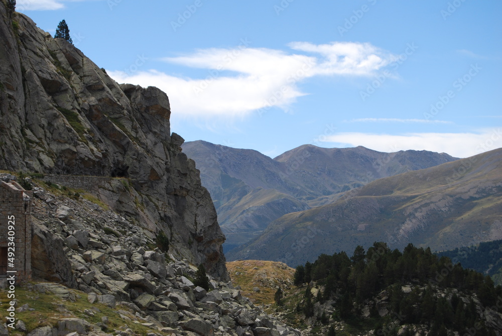 imagen de una pared de montaña con un valle enorme y el cielo azul 