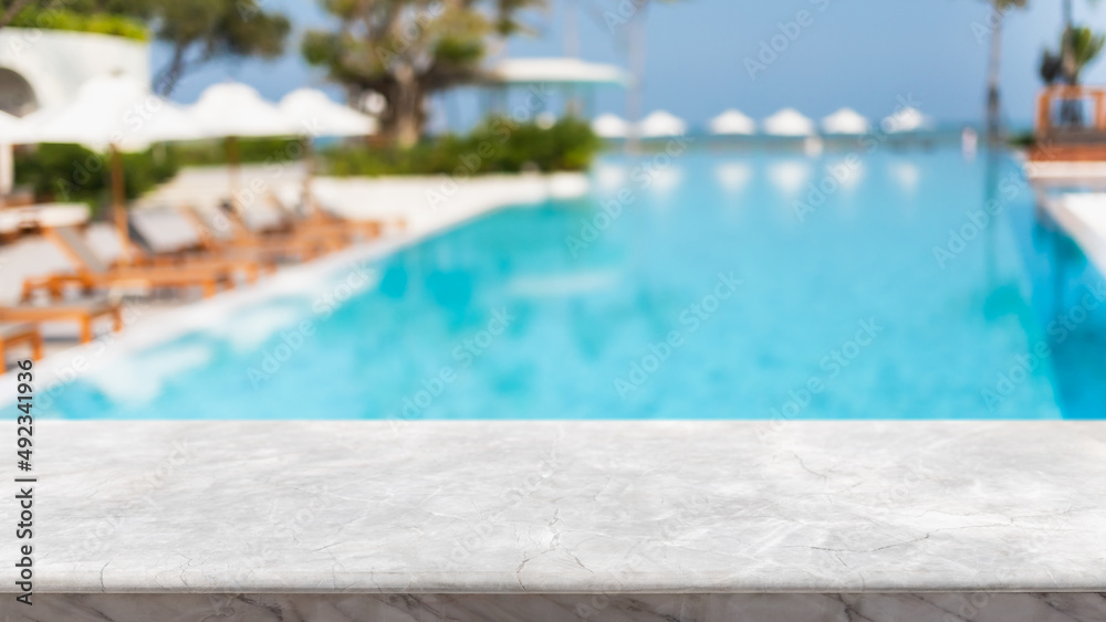 Empty white marble stone table top and blurred swimming pool in tropical resort in summer banner background - can used for display or montage your products. - obrazy, fototapety, plakaty 