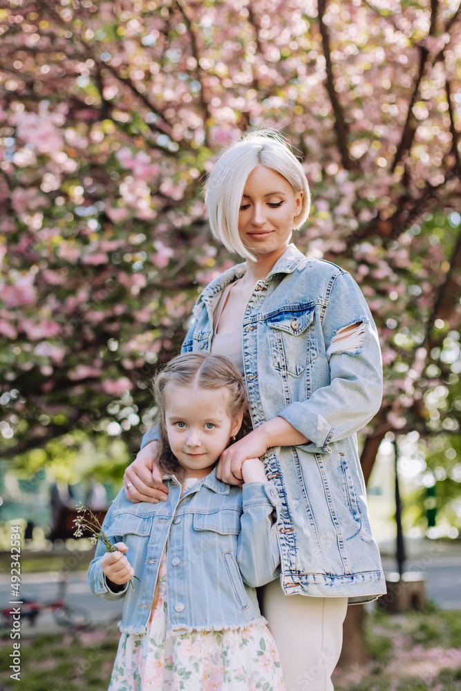 Sakura blossomed. Young mother with her child have fun in the park near the sakura. cherry trees blossom (Uzhhorod City, Ukraine) Sakura blossomed. Young mother with her child have fun in the park near the sakura. cherry trees blossom (Uzhhorod City, Ukraine)
