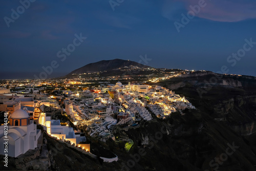 Panoramic view of the picturesque illuminated village of Fira Santorini Greece at night time © DIMITRIOS