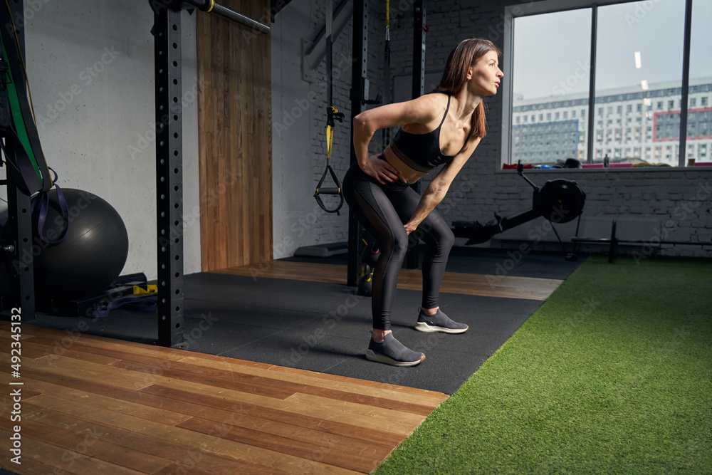 Obraz premium Sporty woman having weight workout in gym