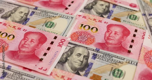 rotation of China yuan or renminbi rmb against US dollar bill of 100 banknotes. Chinese and USA trade war.